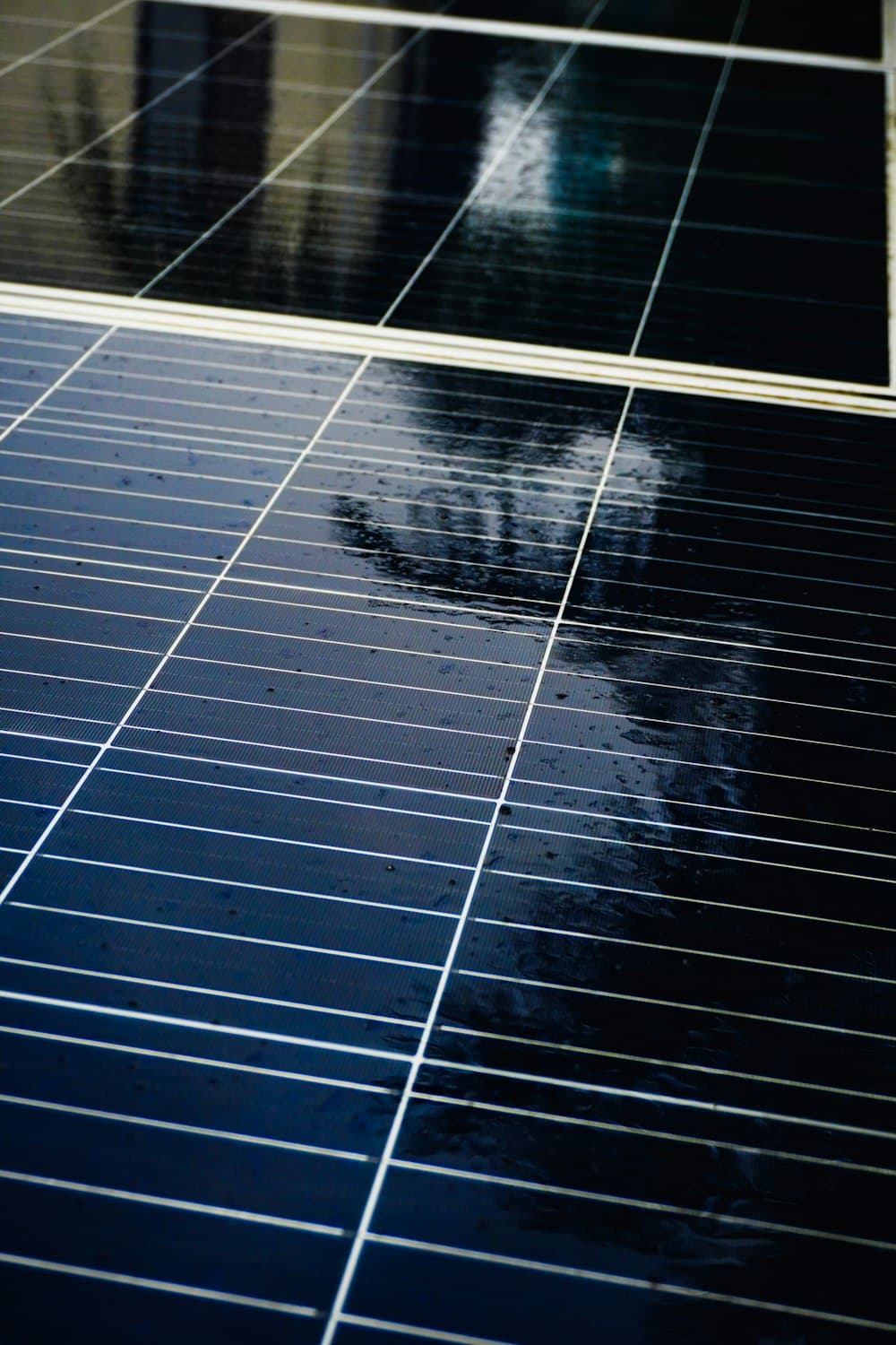 Close-up of a freshly rinsed solar panel, water drying clear on the glass